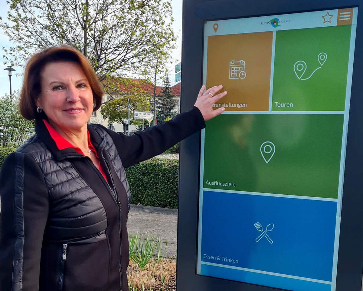 Bild vergrößern: Veltens Bürgermeisterin Ines Hübner vor der neuen digitalen Info-Stele  auf dem Bahnhofsplatz.