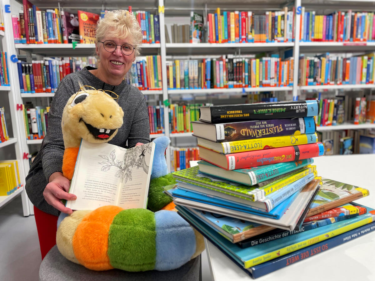 Bild vergrößern: Karina Melerowicz und Leo Lesewurm wetten, dass es die Veltener Kinder schaffen, mindestens 13.239 Bücherseiten aus den Bibliotheksregalen zu lesen.