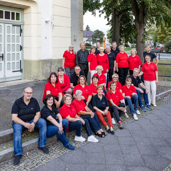 Bild vergr&ouml;&szlig;ern: Freier Chor Velten 1887: Die S&auml;ngerinnen und S&auml;nger sitzen auf der Stufe vor der evangelischen Kirche.