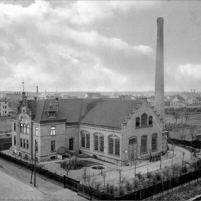 Eine historische Aufnahme von vor 1921, als das Rathaus noch Elektrizitätswerk war. Hoher Schornstein, bodentiefe Fenster und eine große Eingangstür.