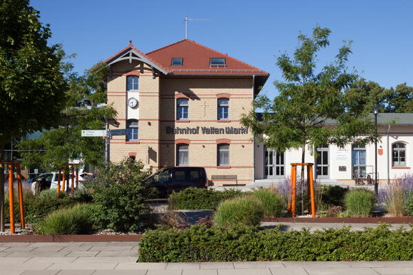 Bild vergrößern: Der Veltener Bahnhof: Ein verklinkertes Gebäude mit der Aufschrift "Bahnhof Velten Mark" und einer großen Uhr.