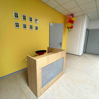 Der Empfang mit gelben Wänden und Tresen im Hort Pusteblume der Löwenzahn Grundschule in Velten Süd.