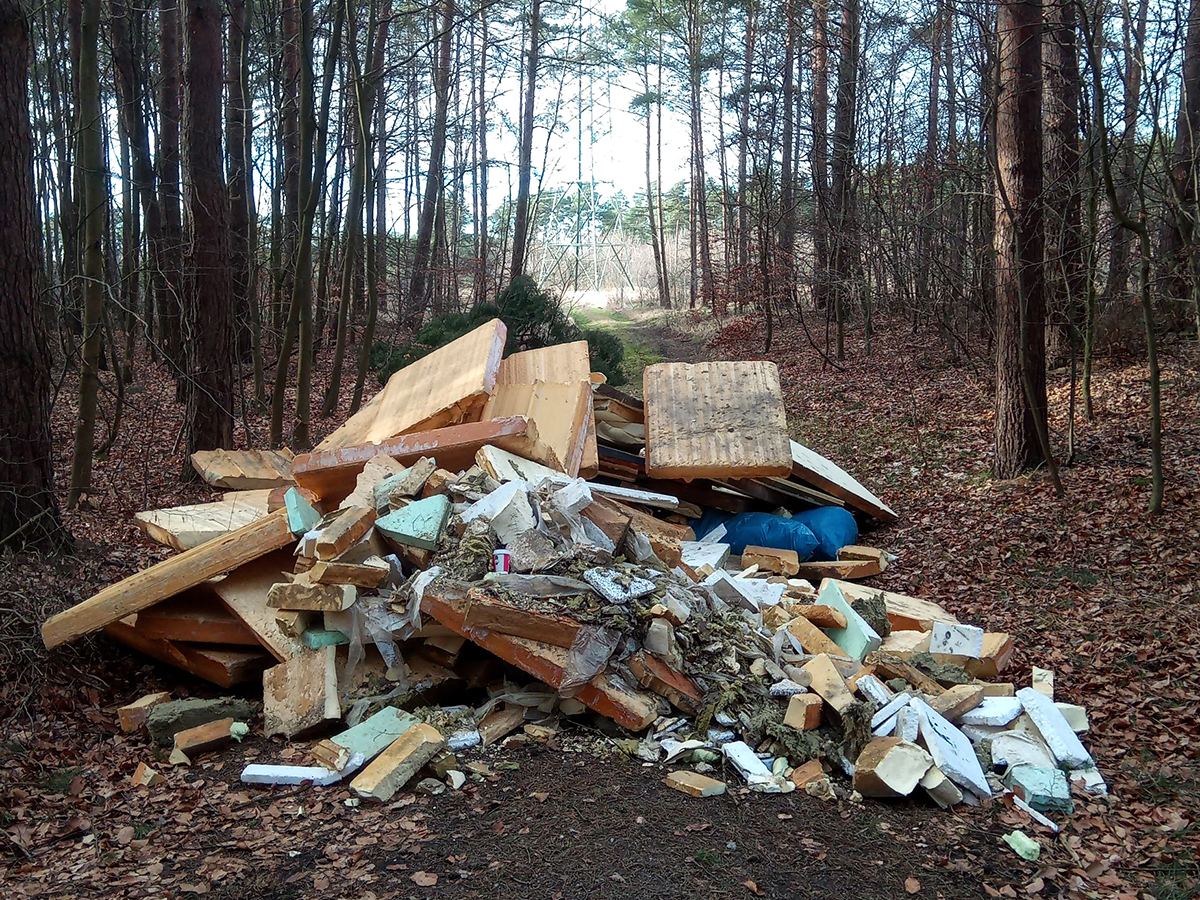Bild vergrößern: Ein Berg Bauschutt und Müll im Wald.