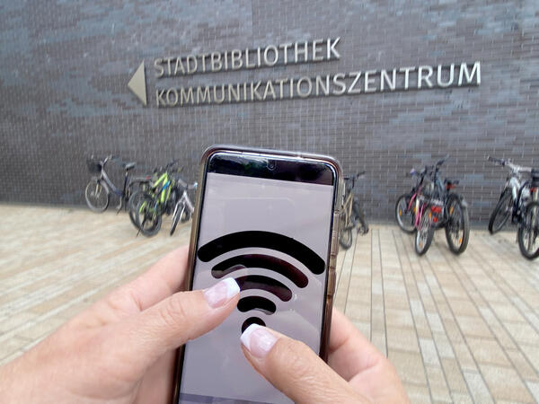 Bild vergrößern: Ein Handy mit dem Wifi Symbol für Wlan in der Stadt.